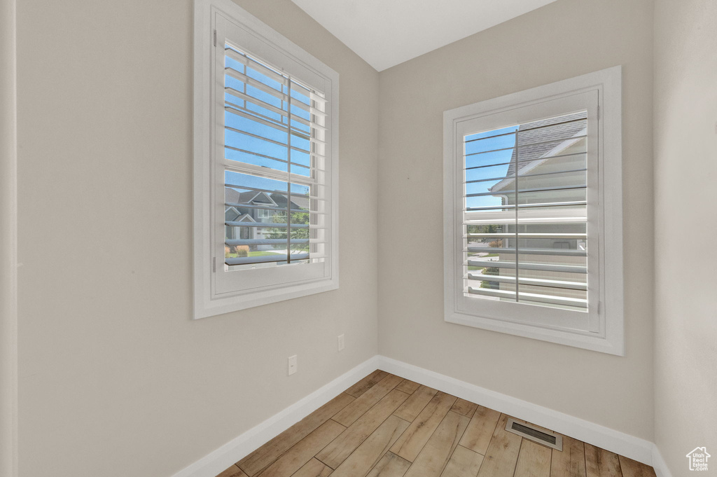 Empty room with baseboards and light wood-style flooring