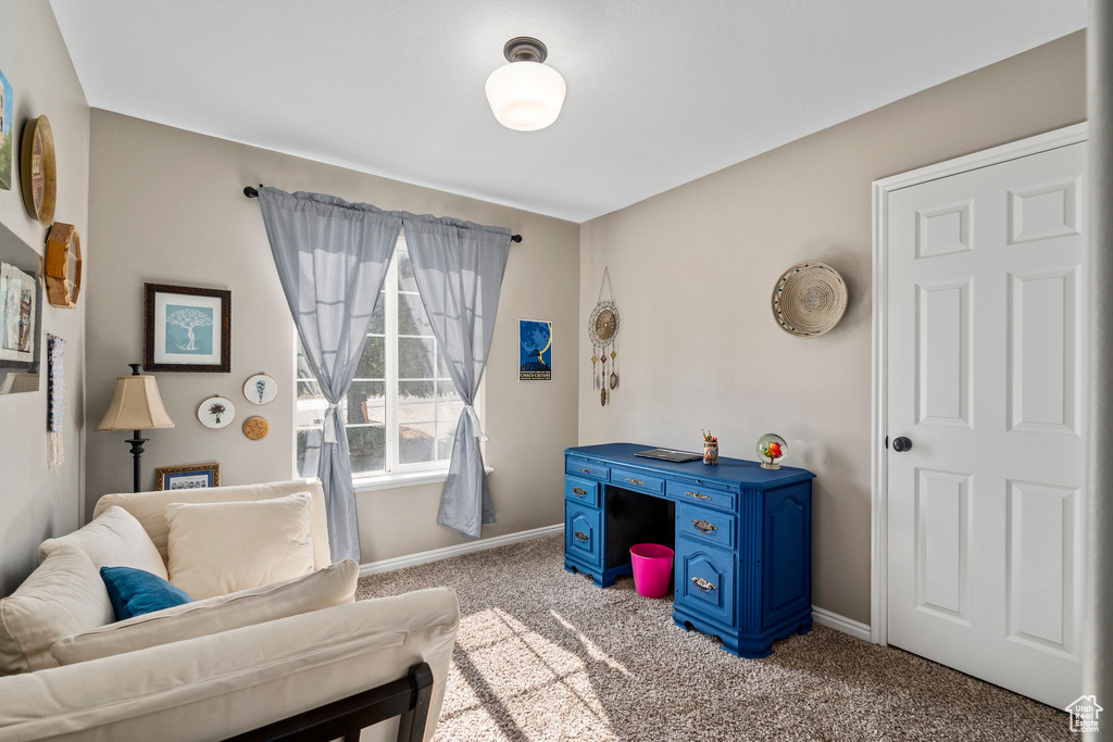 Carpeted living area featuring baseboards