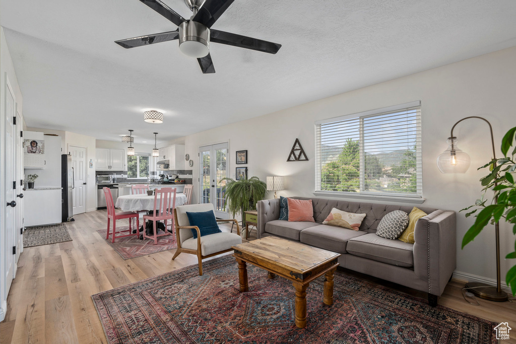 Living room featuring a ceiling fan and light wood-style flooring