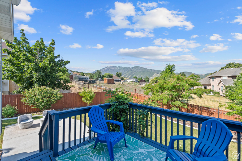 Wooden terrace featuring a mountain view and a fenced backyard