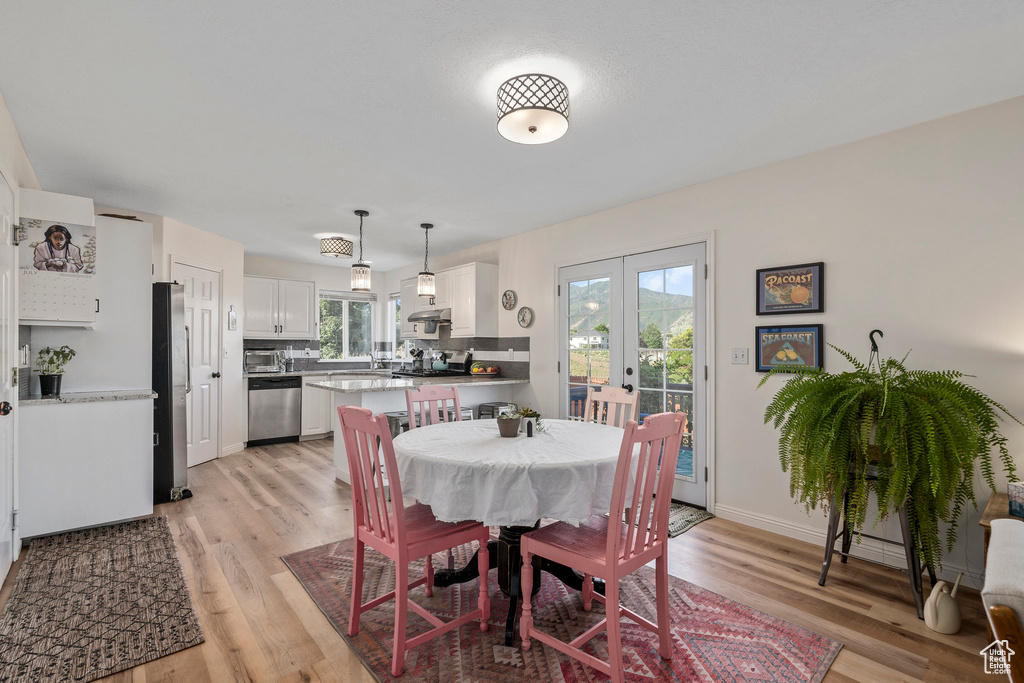 Dining area with french doors, light wood-style flooring, and baseboards