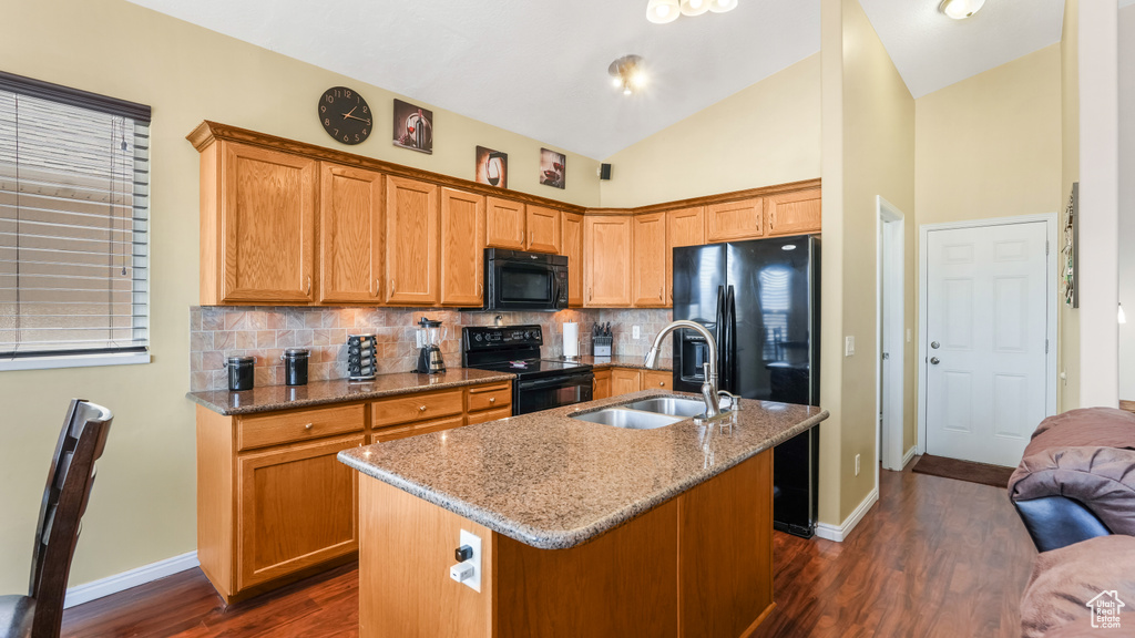 Kitchen featuring black appliances, a sink, dark wood-style floors, backsplash, and high vaulted ceiling