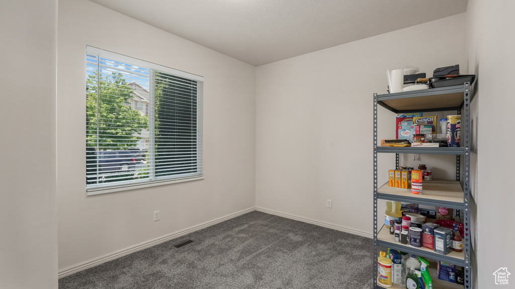 Carpeted spare room featuring baseboards
