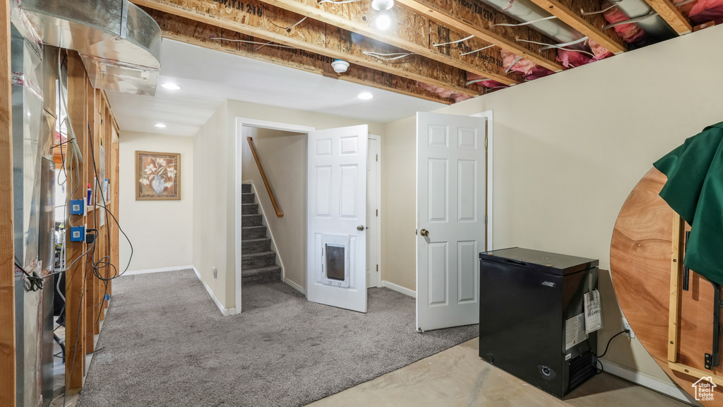 Unfinished basement with stairway, carpet floors, and baseboards