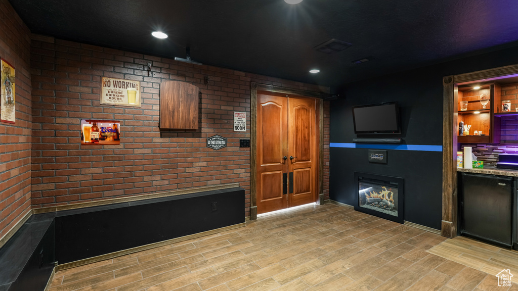 Unfurnished living room with a glass covered fireplace, light wood finished floors, and recessed lighting