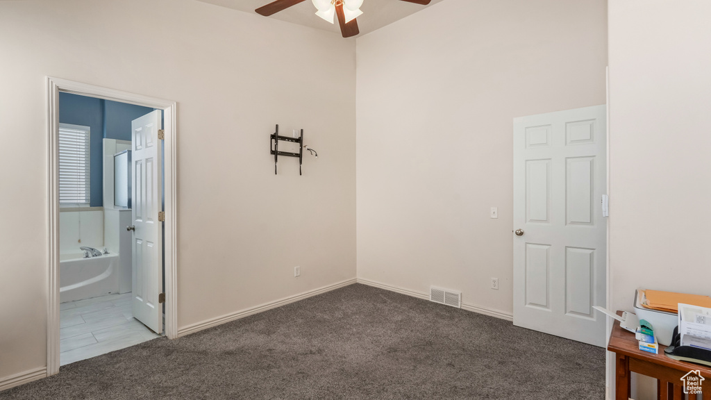 Unfurnished bedroom featuring carpet flooring, a ceiling fan, and ensuite bathroom