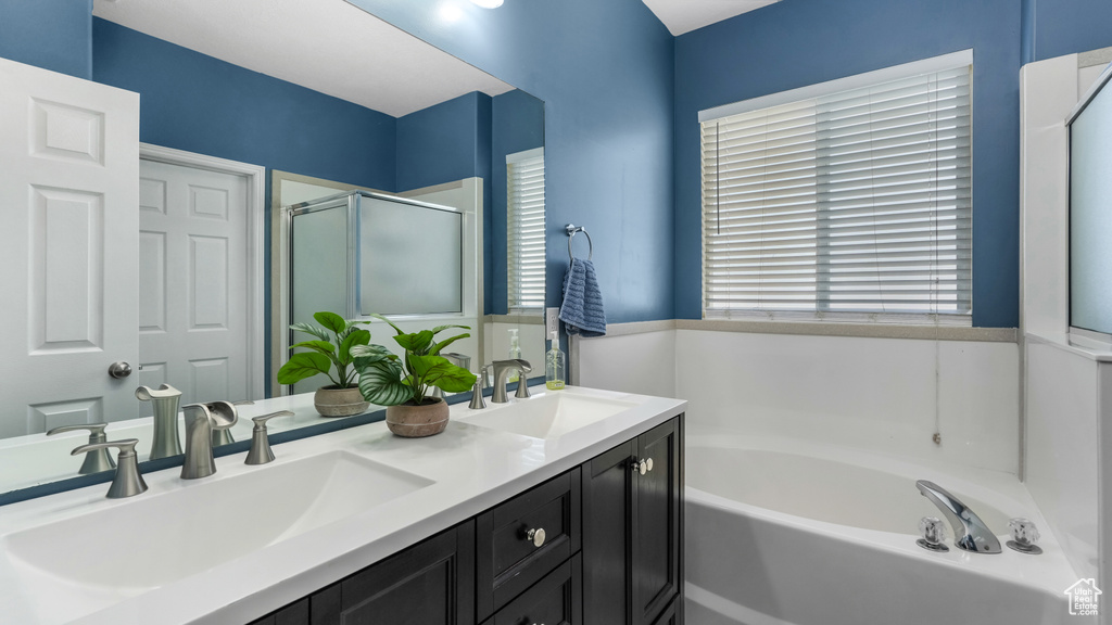 Full bath with a garden tub, a stall shower, and double vanity