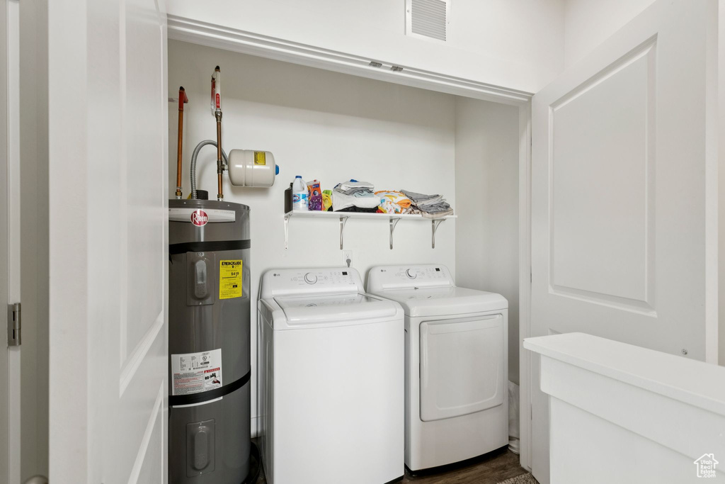 Laundry area featuring strapped water heater and washing machine and dryer