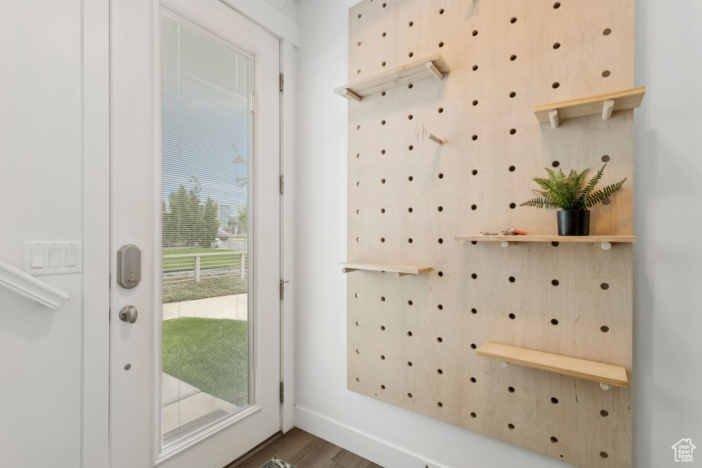 Doorway to outside featuring wood finished floors and baseboards