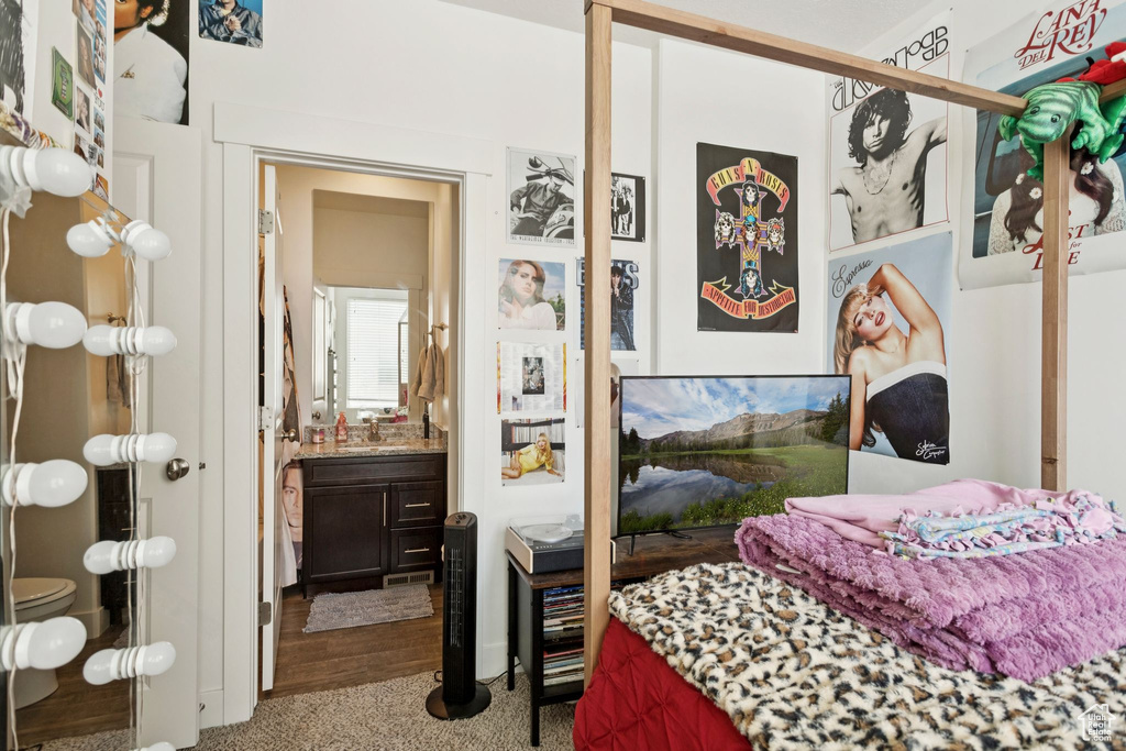 Carpeted bedroom featuring a sink and ensuite bathroom