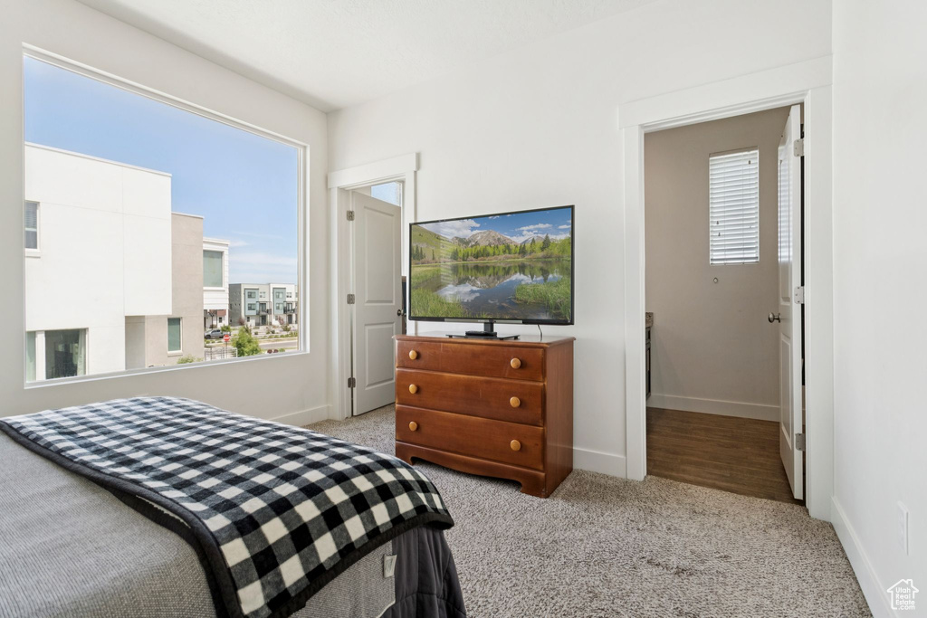 Bedroom with light colored carpet and baseboards