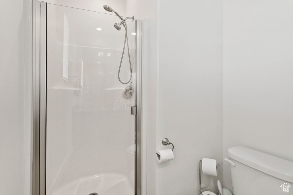 Full bathroom featuring a stall shower and toilet