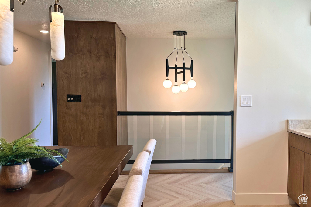 Dining room with a textured ceiling and baseboards