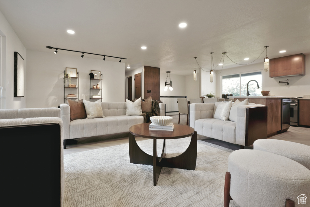 Living room with track lighting, recessed lighting, and light wood finished floors