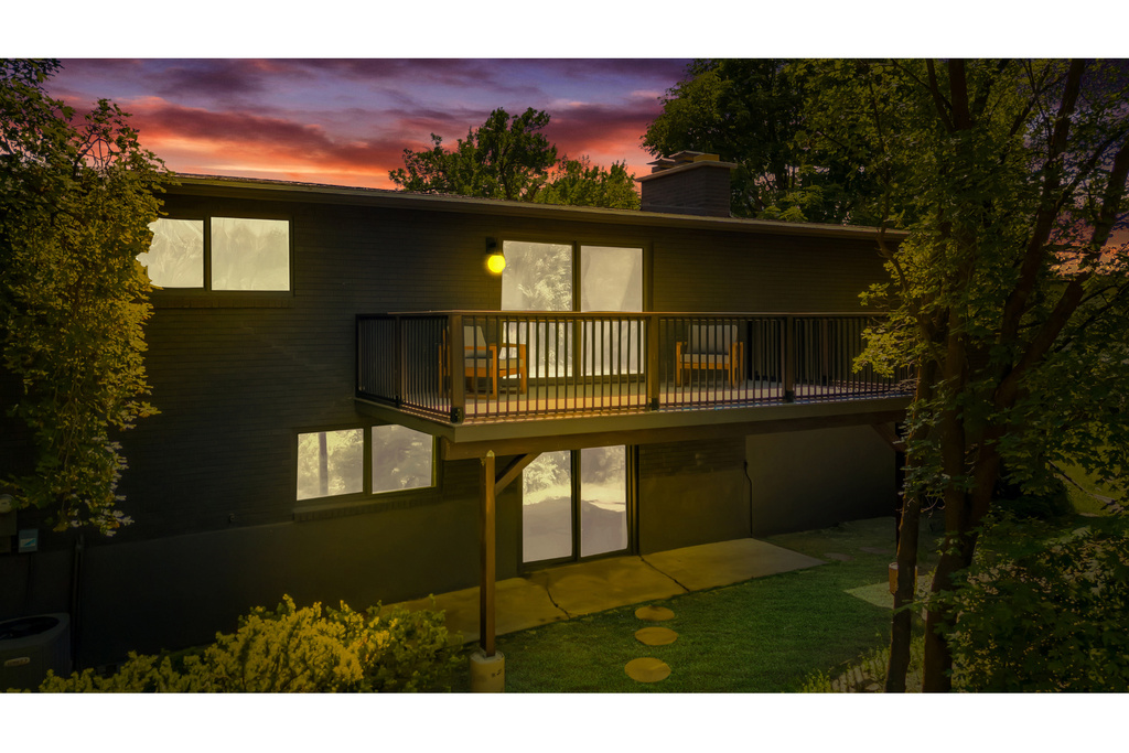 Back of property at dusk with central AC unit and a chimney