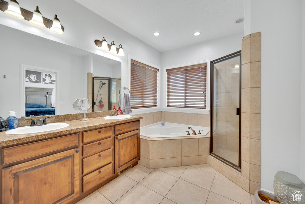 Bathroom featuring ensuite bath, tile patterned floors, a bath, a stall shower, and double vanity