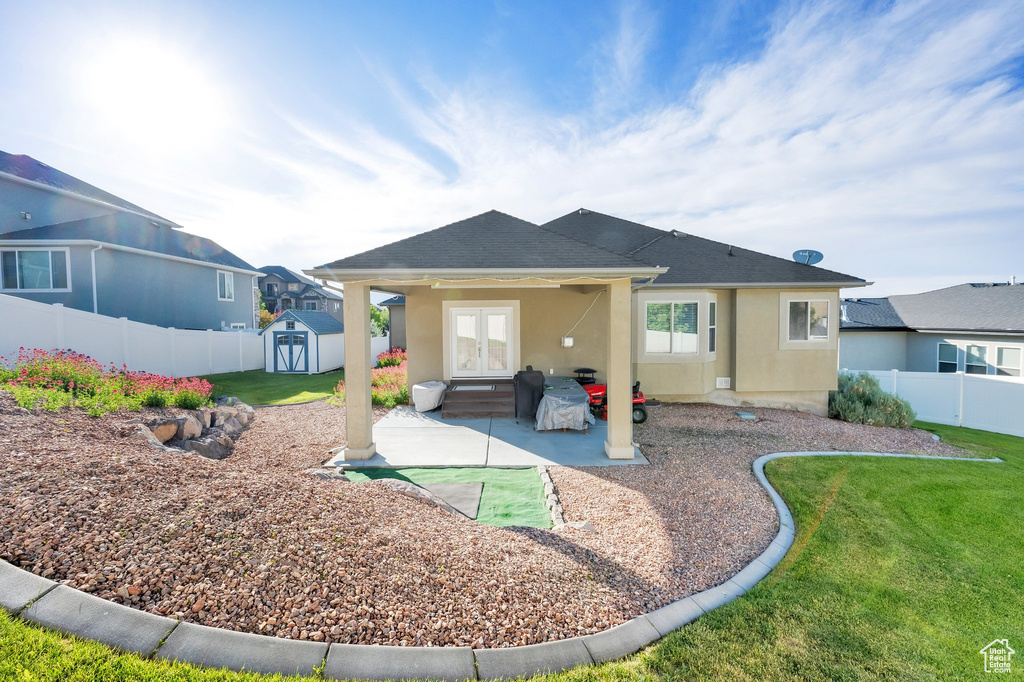 Back of property featuring french doors, a patio, stucco siding, and a shingled roof