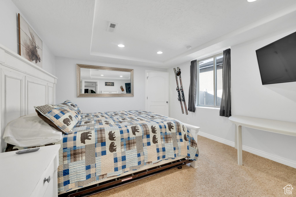 Bedroom featuring recessed lighting, baseboards, carpet, and a tray ceiling