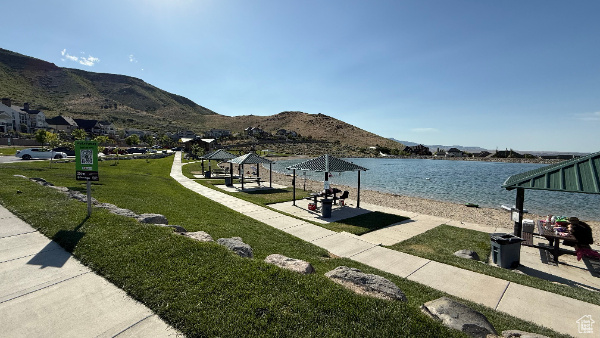 View of property\'s community with a yard and a water and mountain view