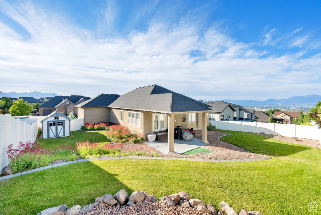 Rear view of house with a patio area, a mountain view, a residential view, and stucco siding