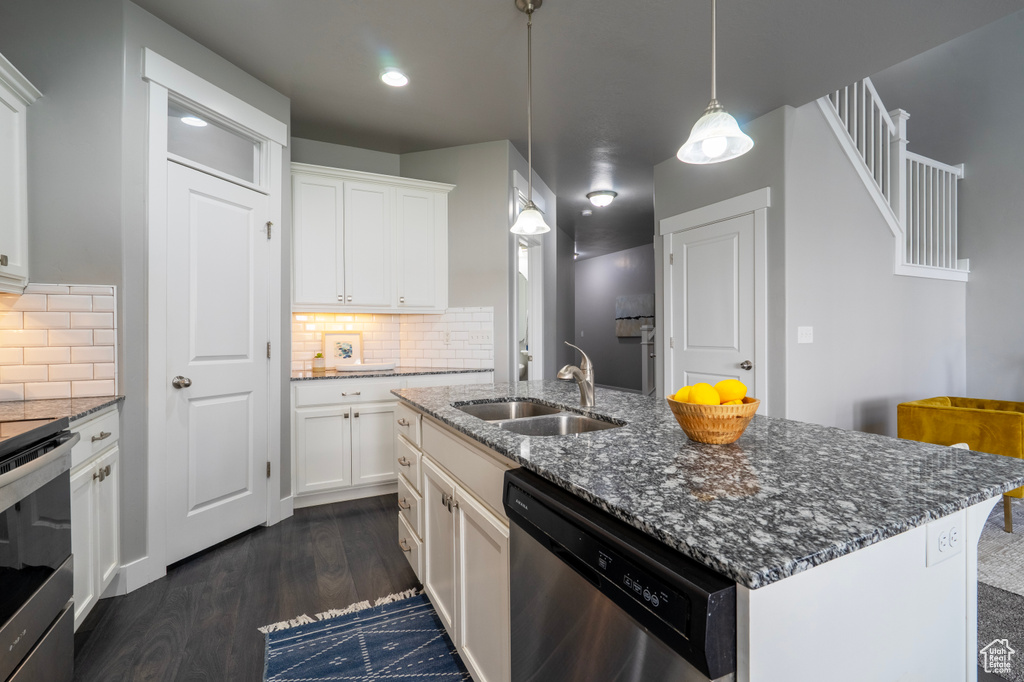 Kitchen with stainless steel appliances, a sink, dark wood-type flooring, decorative backsplash, and recessed lighting
