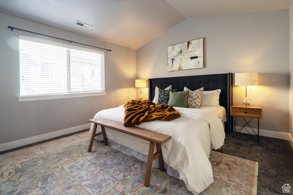 Bedroom with lofted ceiling, carpet, and baseboards