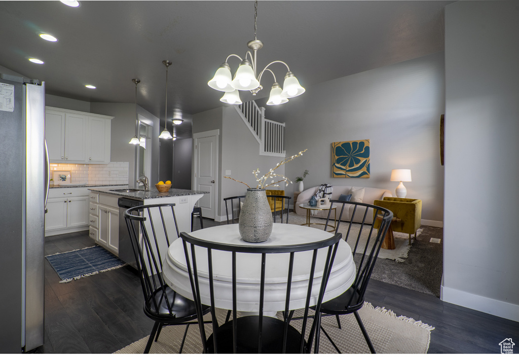 Dining room featuring dark wood-style flooring, baseboards, a chandelier, and recessed lighting