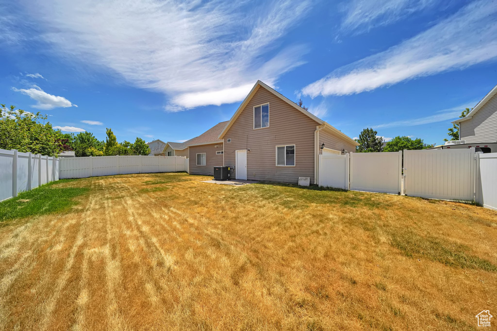 Rear view of property featuring central AC and a garage