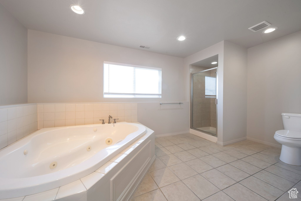 Full bath featuring a tub with jets, toilet, a stall shower, baseboards, and tile patterned floors