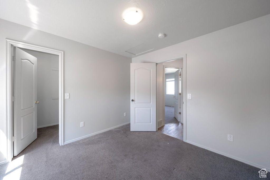Unfurnished bedroom with carpet, baseboards, and a spacious closet