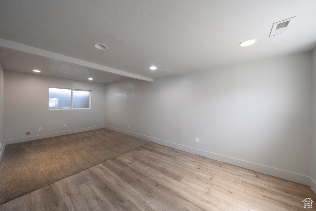 Empty room featuring baseboards, light wood-type flooring, and recessed lighting