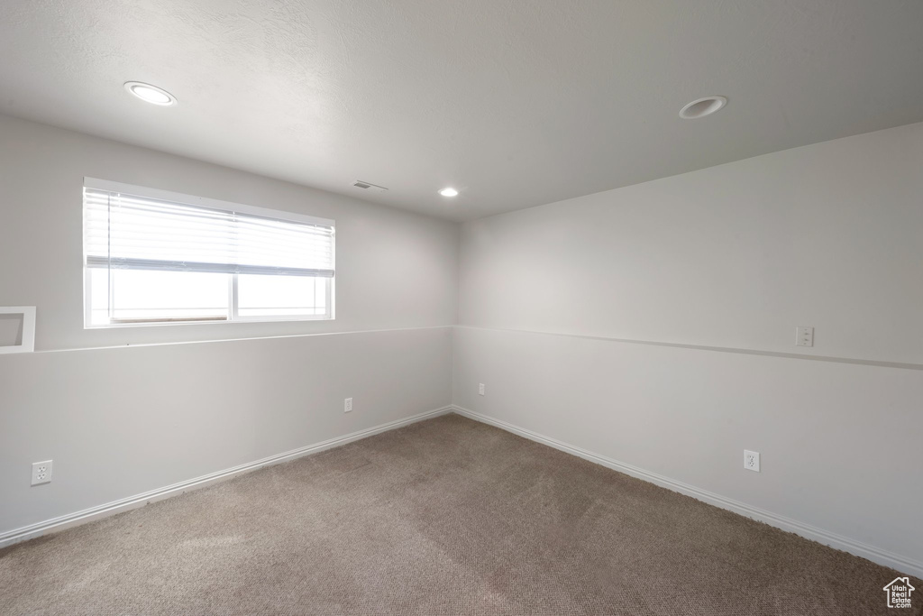 Carpeted empty room featuring recessed lighting and baseboards
