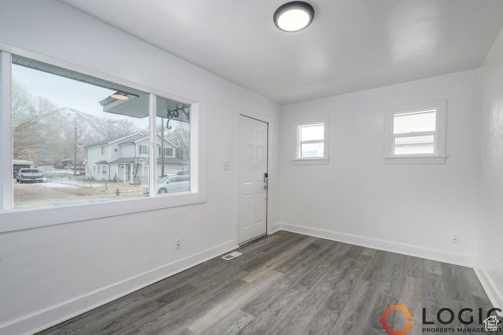 Spare room featuring baseboards and dark wood finished floors