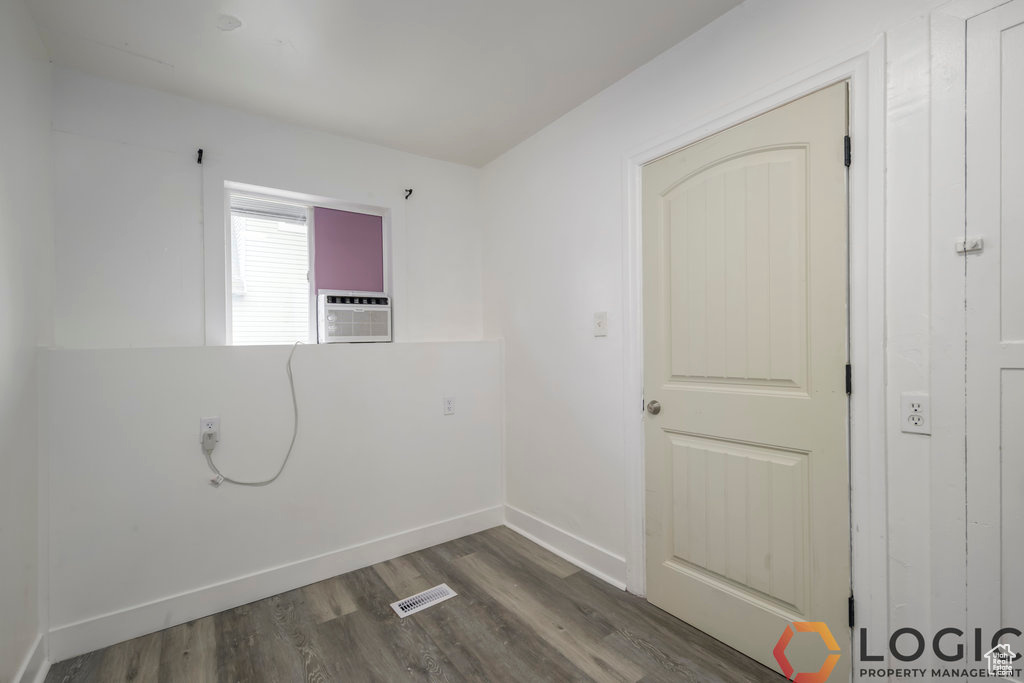 Spare room with wood finished floors, baseboards, and cooling unit