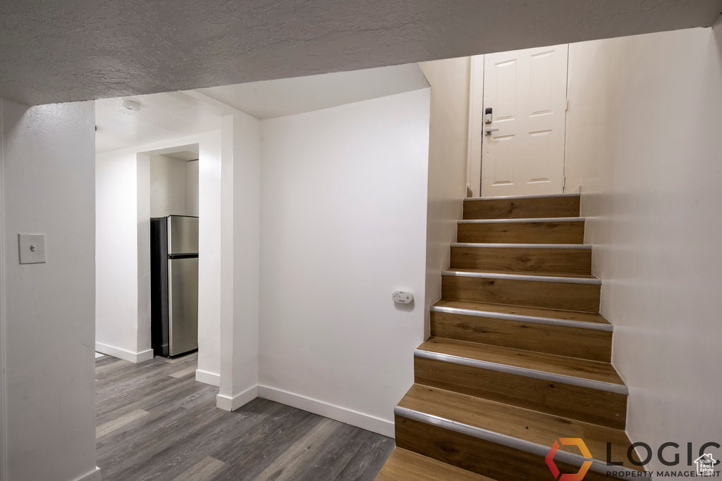 Staircase with wood finished floors and baseboards