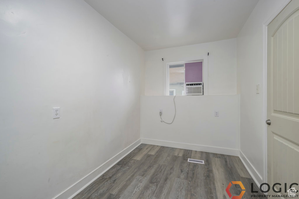 Empty room with baseboards, wood finished floors, and cooling unit