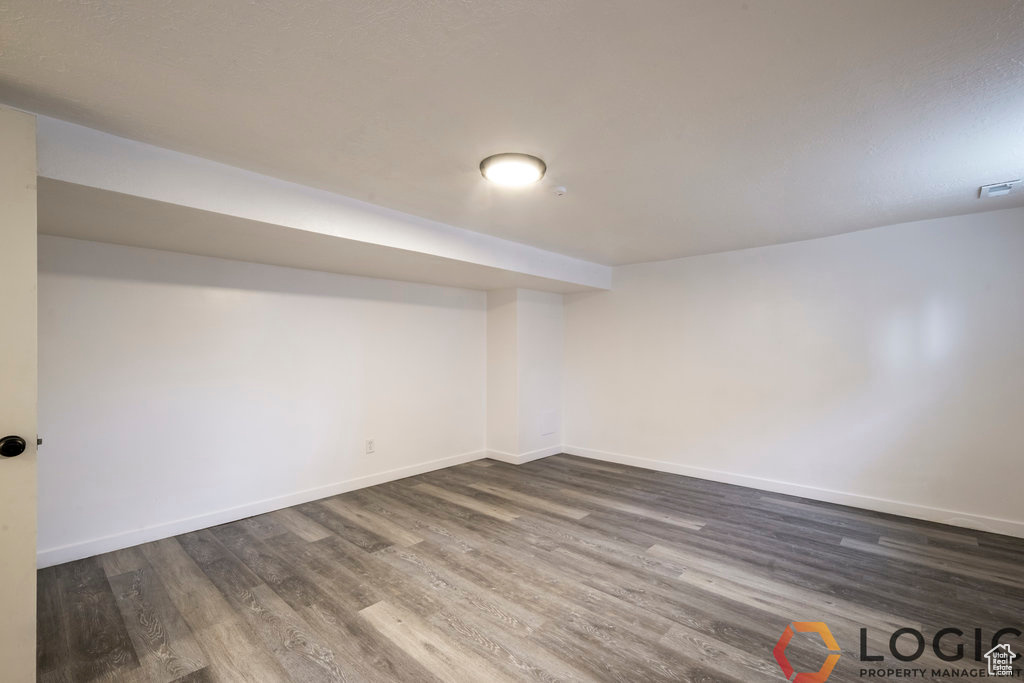 Finished basement with dark wood-style floors and baseboards