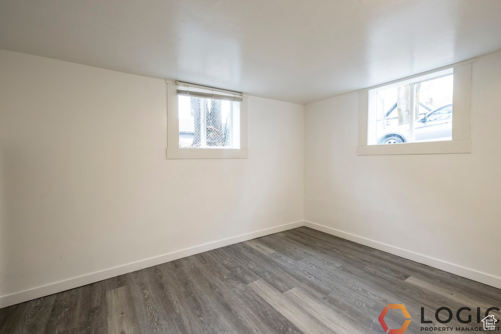 Below grade area with dark wood-style flooring, baseboards, and healthy amount of natural light