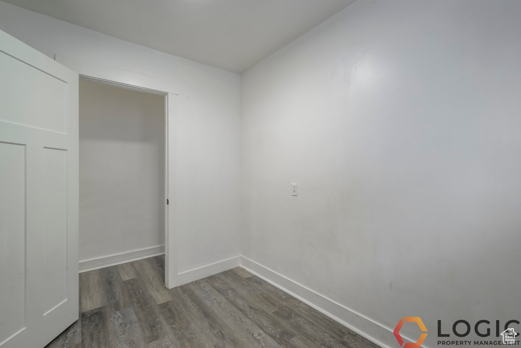 Unfurnished bedroom with dark wood finished floors and baseboards