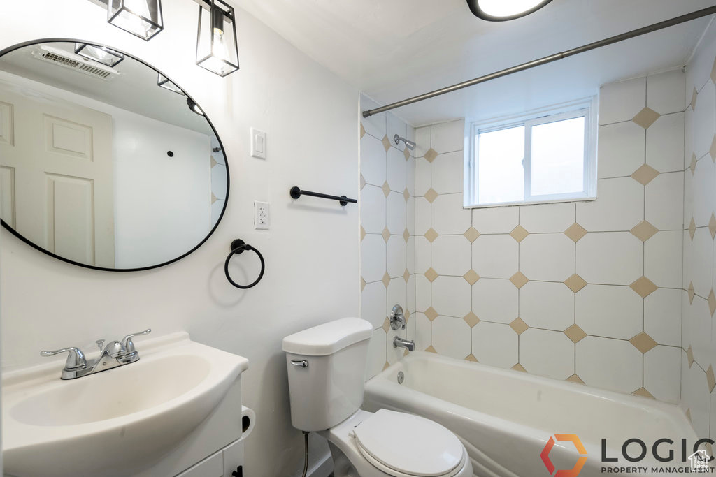 Full bathroom featuring toilet, bathtub / shower combination, and vanity
