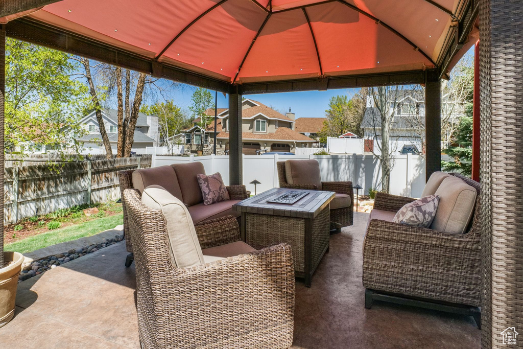 Fenced backyard with an outdoor living space, a residential view, a gazebo, and a patio area
