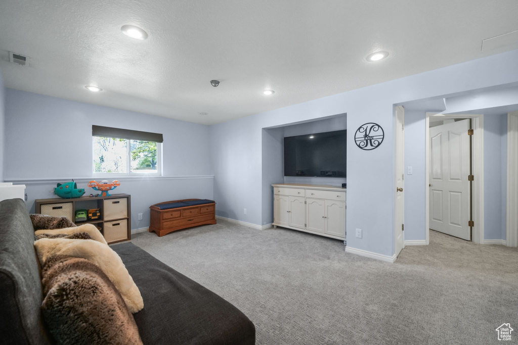 Living room with light carpet, recessed lighting, and baseboards