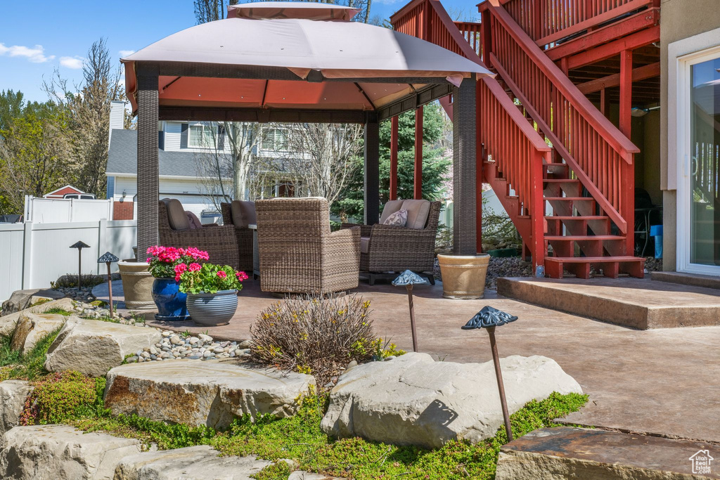 View of patio / terrace featuring stairway, a gazebo, an outdoor hangout area, and a wooden deck
