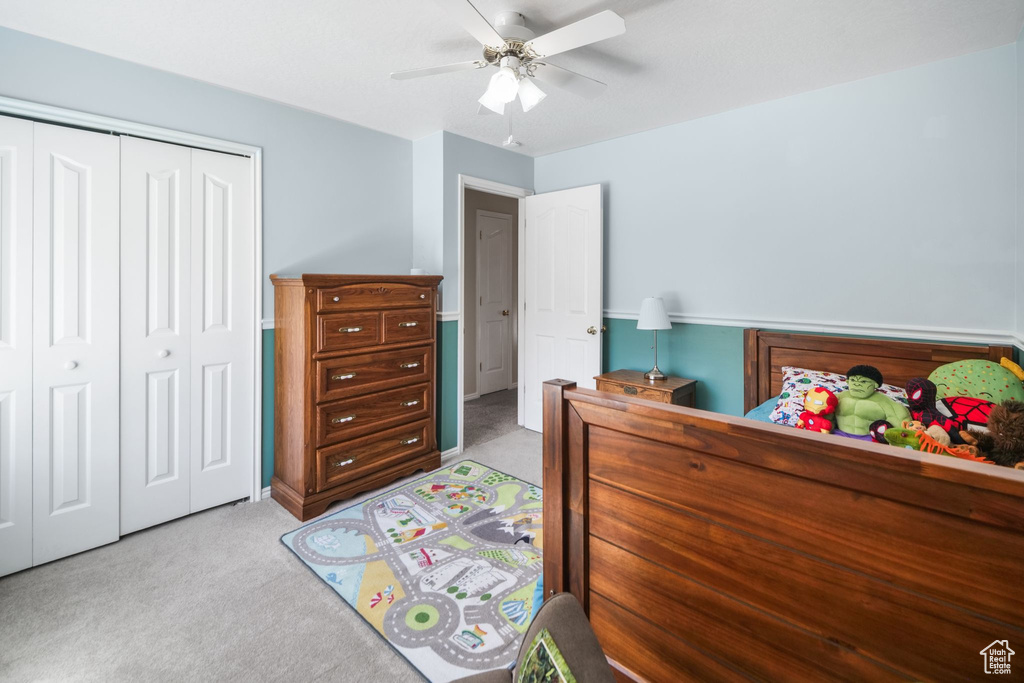 Carpeted bedroom featuring a closet and a ceiling fan