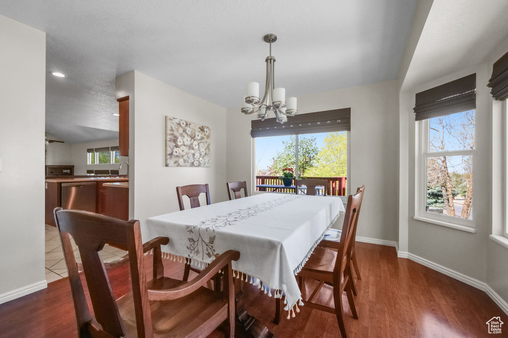 Dining room featuring a chandelier, plenty of natural light, baseboards, and wood finished floors