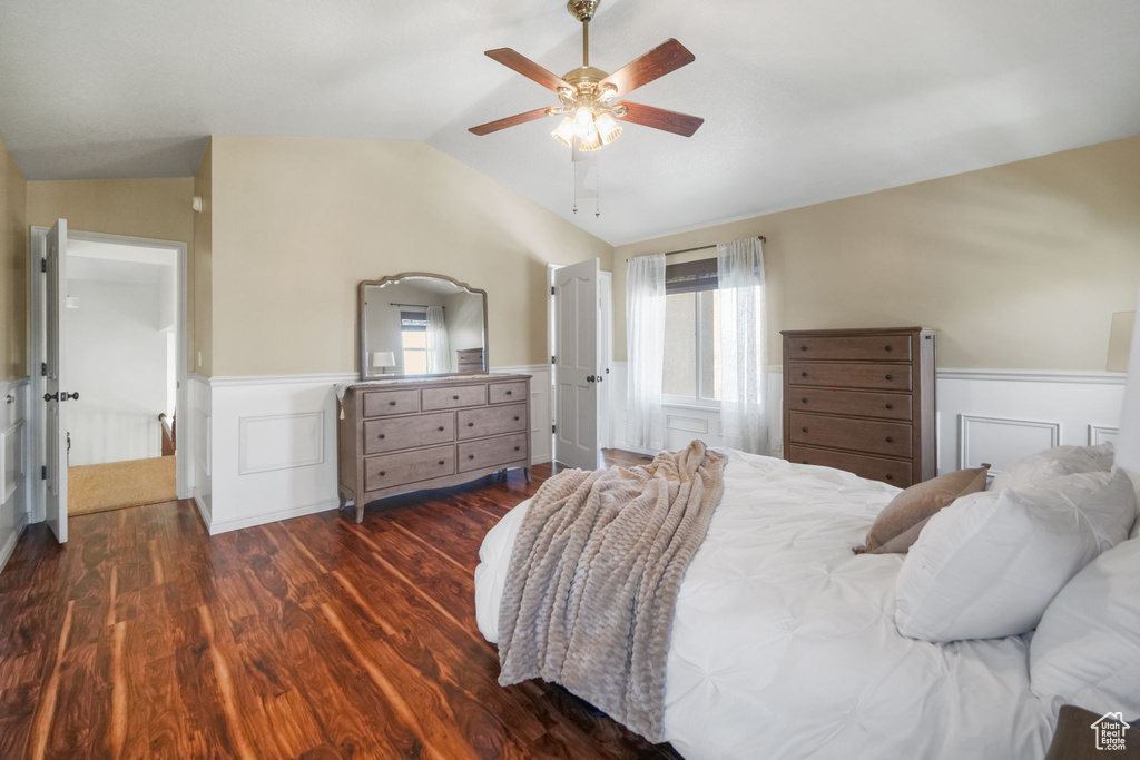 Bedroom with wainscoting, wood finished floors, vaulted ceiling, and ceiling fan