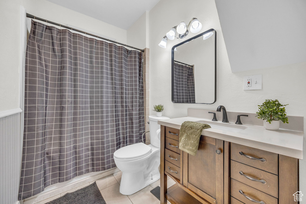 Full bathroom with toilet, vanity, tile patterned floors, and a shower with curtain