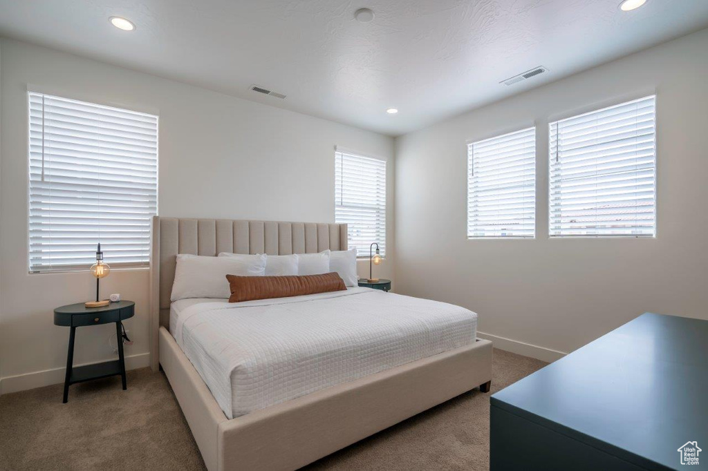 Bedroom with light carpet, baseboards, and recessed lighting