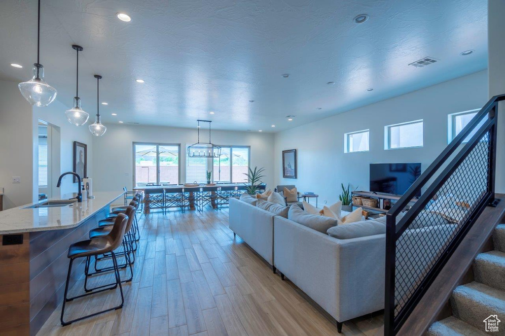 Living room with light wood-type flooring and recessed lighting