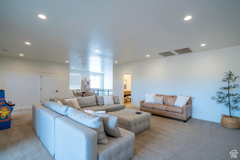 Living room with light colored carpet, recessed lighting, and baseboards